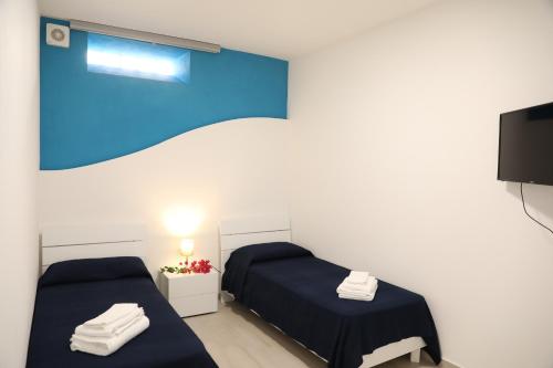 a room with two beds and a tv at Covo dei Marinai in Cava dʼAliga