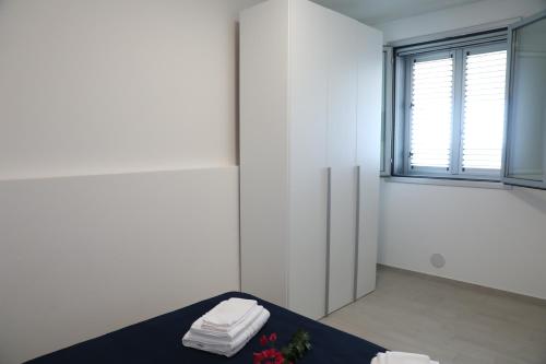 a white room with a table with towels and a window at Covo dei Marinai in Cava dʼAliga