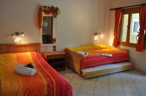 a bedroom with two beds and a mirror at Lysistrata Bungalows in Potos