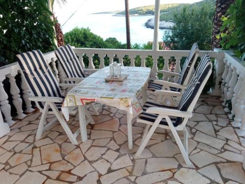 - une table et deux chaises sur la terrasse dans l'établissement Apartment Sliskovic, à Vis
