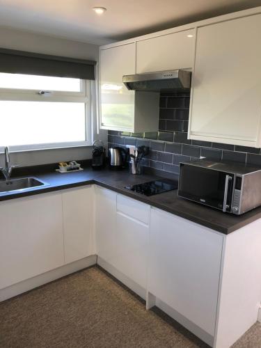 a kitchen with white cabinets and a microwave at The Annexe rural retreat near Bath in Bath