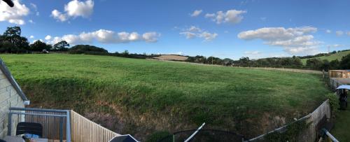 a large field of grass with a fence and a sky at The Annexe rural retreat near Bath in Bath