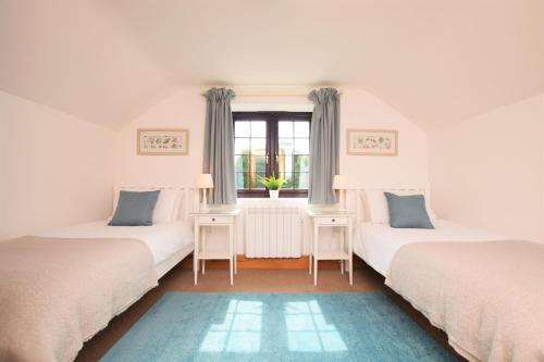 una stanza con tre letti e una finestra di Byre Cottage, Lympstone - near Exmouth and Exeter a Exmouth