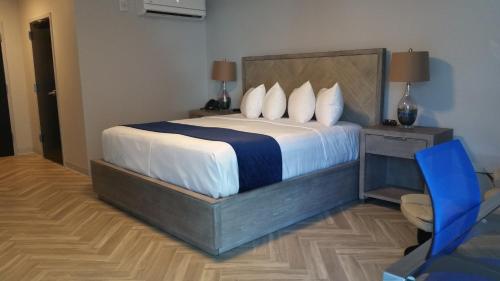 a bedroom with a large bed with a blue chair at Athens Central Hotel in Athens