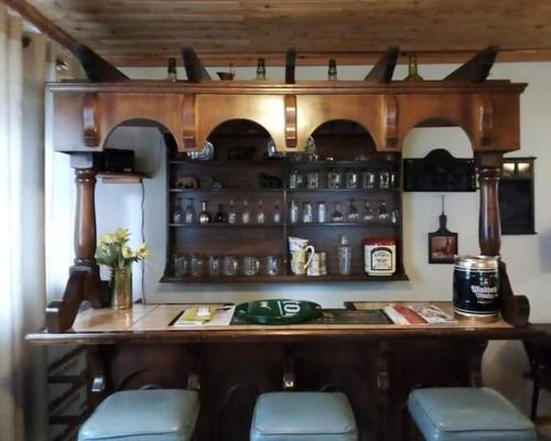 een bar met blauwe stoelen en een houten bar bij Old Post Office Inn in Graskop
