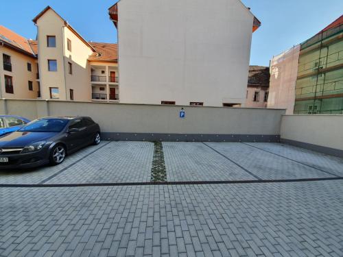 a car parked in a parking lot next to a building at gyorapartman-TOP in Győr
