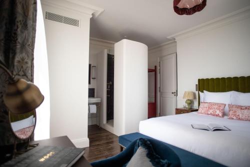 a bedroom with a white bed with a book on it at La Maison d'Estournel in Saint-Estèphe