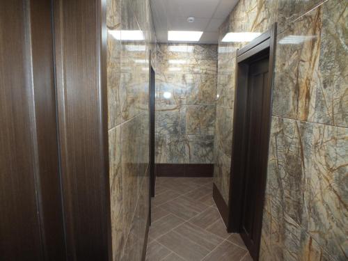 y baño con ducha a ras de suelo y puerta de cristal. en Hotel Persona, en Yuzhnoural'sk