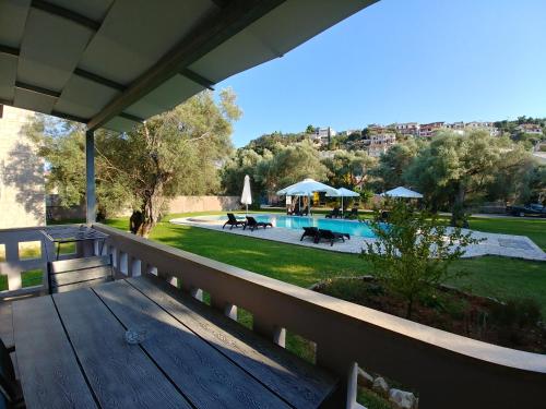 porche con banco de madera junto a la piscina en Villa *FRYNI*/5' from sea & center/Mountain View en Lefkada