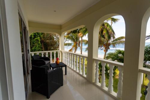 a room with a balcony with a view of the ocean at Villa Bella in Mahe