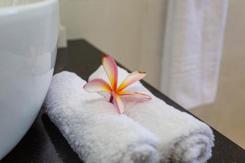 a flower sitting on top of two rolled towels at Villa Bella in Mahe