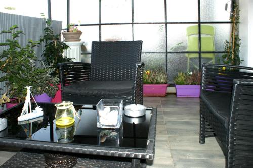 a chair and a table in a room with plants at Sunny studio with Parthenon view balcony in Athens