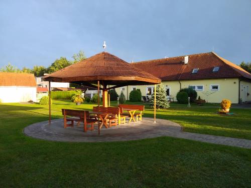 a table and chairs under a large umbrella in a yard at Penzion Kosky in Hamr