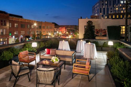 a rooftop patio with tables and chairs on a building at Graduate by Hilton Columbus in Columbus