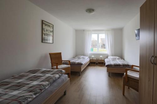 um quarto com duas camas e cadeiras e uma janela em Gästehaus Höltig em Havekost