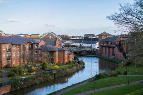 une rivière dans une ville avec des bâtiments à côté d'une ville dans l'établissement Central BnB with secure parking, à Chester