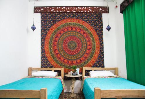 a room with two beds and a tapestry on the wall at Casa San Benito Abad in Cartagena de Indias