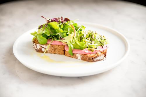 a plate with a sandwich and a salad on it at Hotel Babula am Augarten in Vienna