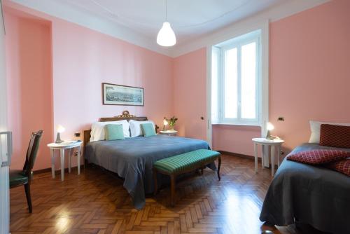 a bedroom with pink walls and a bed and a couch at Elegante Casa Liberty in Milan