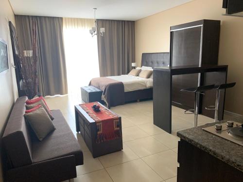 um quarto de hotel com um quarto com uma cama e um sofá em CONDO NORDELTA - Apart Departamento - COMPLEJO WYNDHAM - BAHIA GRANDE em Tigre