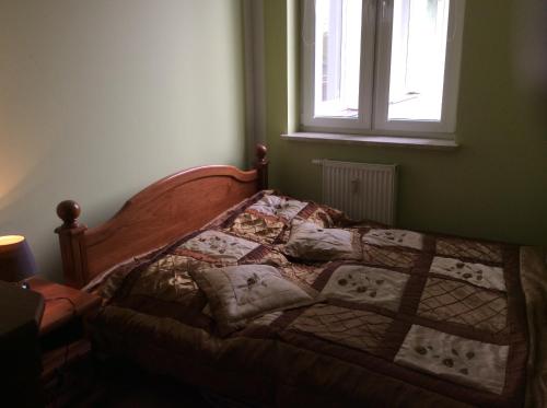 a bed with a quilt on it in a bedroom at Wakacje Kołobrzeg EU in Kołobrzeg