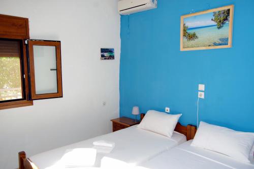 2 camas en una habitación con una pared azul en Athina, en Koinira