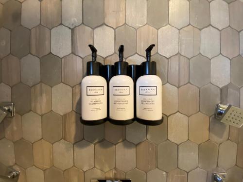 a row of bottles on a wall in a bathroom at Travelodge by Wyndham Santa Maria in Santa Maria