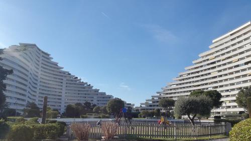 a large white building with trees in front of it at Lovely apartment in Marina Baie des Anges- Baronnet - Sew view, free parking spaces on site, restaurants, beach, supermarket in Villeneuve-Loubet