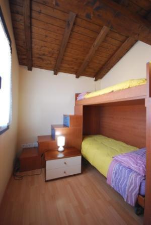 a bedroom with two bunk beds and a table at Komote in San Zeno