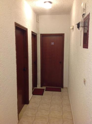 a hallway with two brown doors and a tile floor at Aialion studios & apartments - Steve Apartments in Rhodes Town