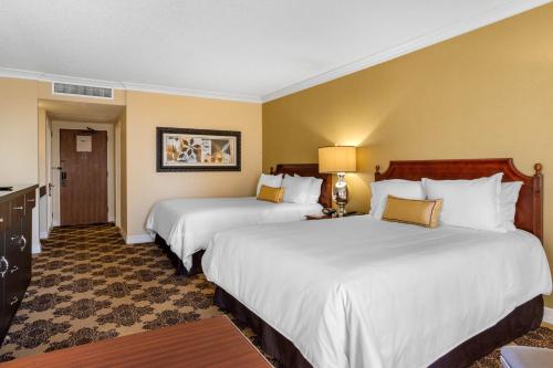 two beds in a hotel room with yellow walls at Omni Houston Hotel in Houston