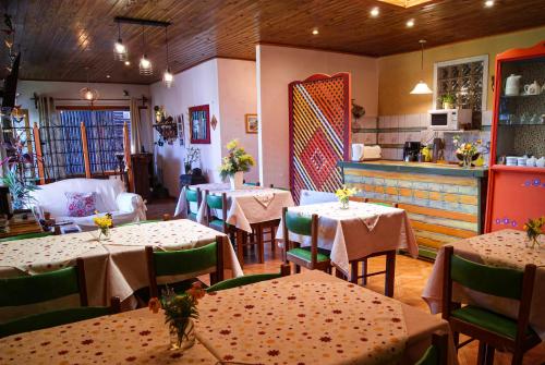 a restaurant with tables and chairs and a kitchen at Hospedaje Flores del Sur in El Calafate