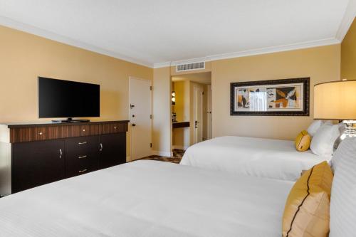a hotel room with two beds and a flat screen tv at Omni Houston Hotel in Houston