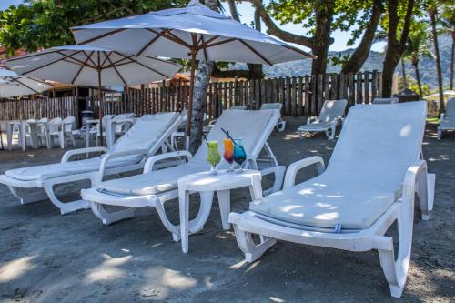 a group of chairs and umbrellas on a beach at Vistabela Resort & Spa in São Sebastião