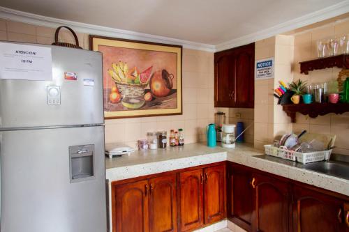 a kitchen with a refrigerator and a painting on the wall at Casa San Benito Abad in Cartagena de Indias