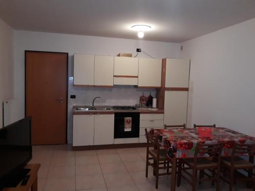 a kitchen with a table with chairs and a sink at Magic Riva Apartment in Riva del Garda