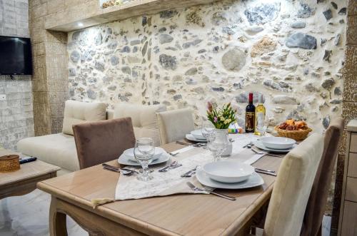 einen Holztisch mit Tellern und Weingläsern darauf in der Unterkunft Epaminontas Captain in Agia Galini