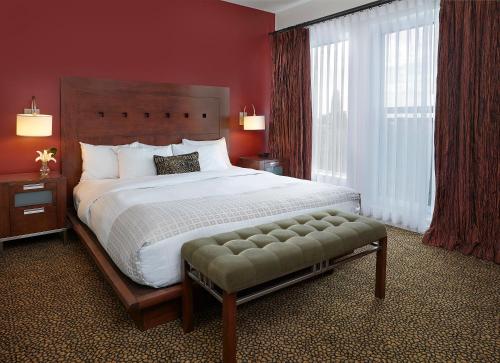 a bedroom with a large bed with red walls at Metterra Hotel on Whyte in Edmonton