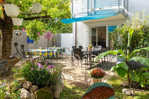 a patio with a table and chairs in a garden at Gästehaus Moser in Weil am Rhein