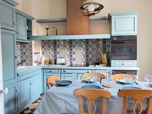 a kitchen with a table and chairs in a kitchen at la Porte aux Dames in Romorantin