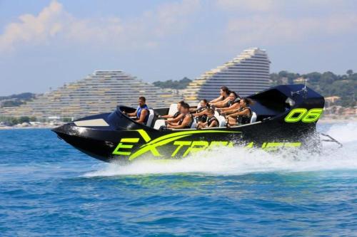 a group of people riding on a jet ski in the water at Lovely apartment in Marina Baie des Anges- Baronnet - Sew view, free parking spaces on site, restaurants, beach, supermarket in Villeneuve-Loubet