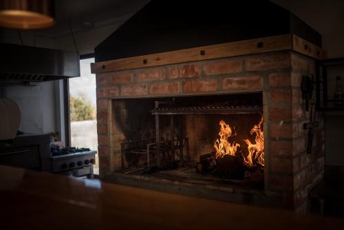 una chimenea de ladrillo con fuego en la cocina en Angelica's Rental House, en Puerto Natales