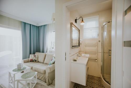 加茨比亚格拉Apartamenty Biała Perła, sauna, jacuzzi, rowery的带沙发和桌子的小客厅
