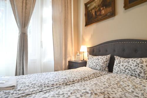 a bedroom with a bed and a window at Tulipán Villa Panzió in Szolnok