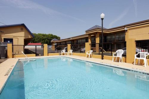 a large swimming pool with chairs and a building at Americas Best Value Inn Alachua in Alachua