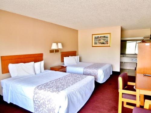 a hotel room with two beds and a chair at Americas Best Value Inn Alachua in Alachua