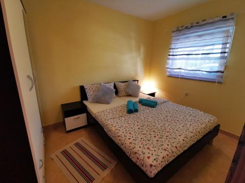 una camera da letto con un letto con cuscini blu e una finestra di Apartments Ivan a Vir (Puntadura)