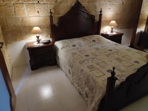1 dormitorio con 1 cama grande y 2 mesitas de noche en Amelia's House of Character, en Cospicua