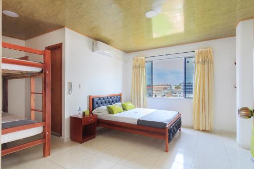 a bedroom with two bunk beds and a window at Hotel El Rubí in Bucaramanga