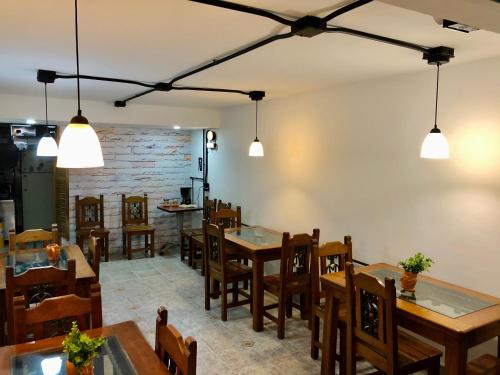 a dining room with tables and chairs and lights at Hotel Casa Malibú in Medellín